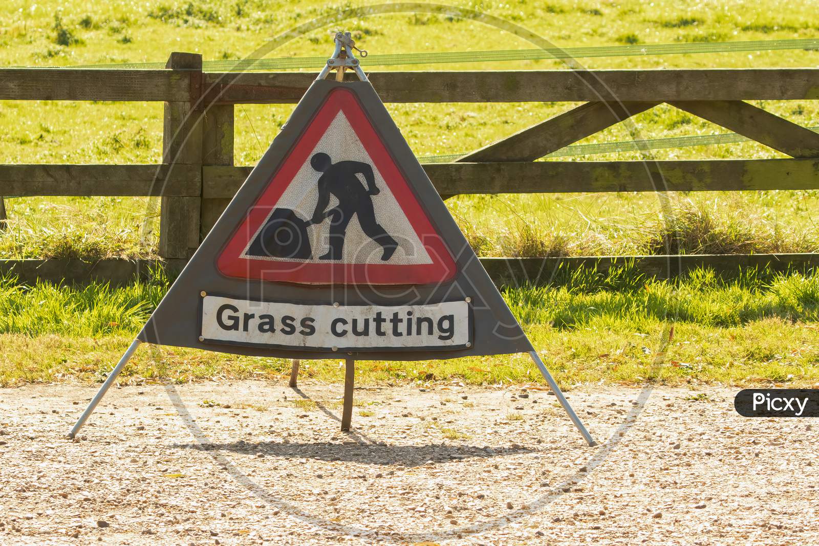 Triangle Warning Sign With Warning Saying Grass Cutting With Copy Space