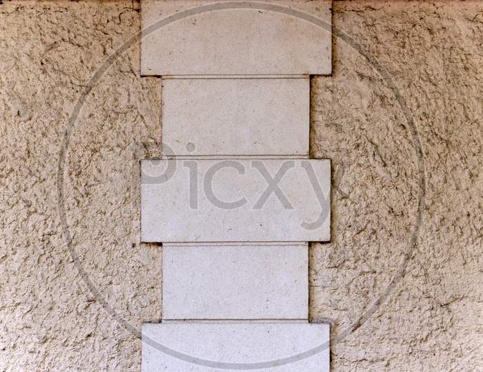 Concrete Rectangular Tile Pattern Between Sand Wall With Rough Texture Cream In Color