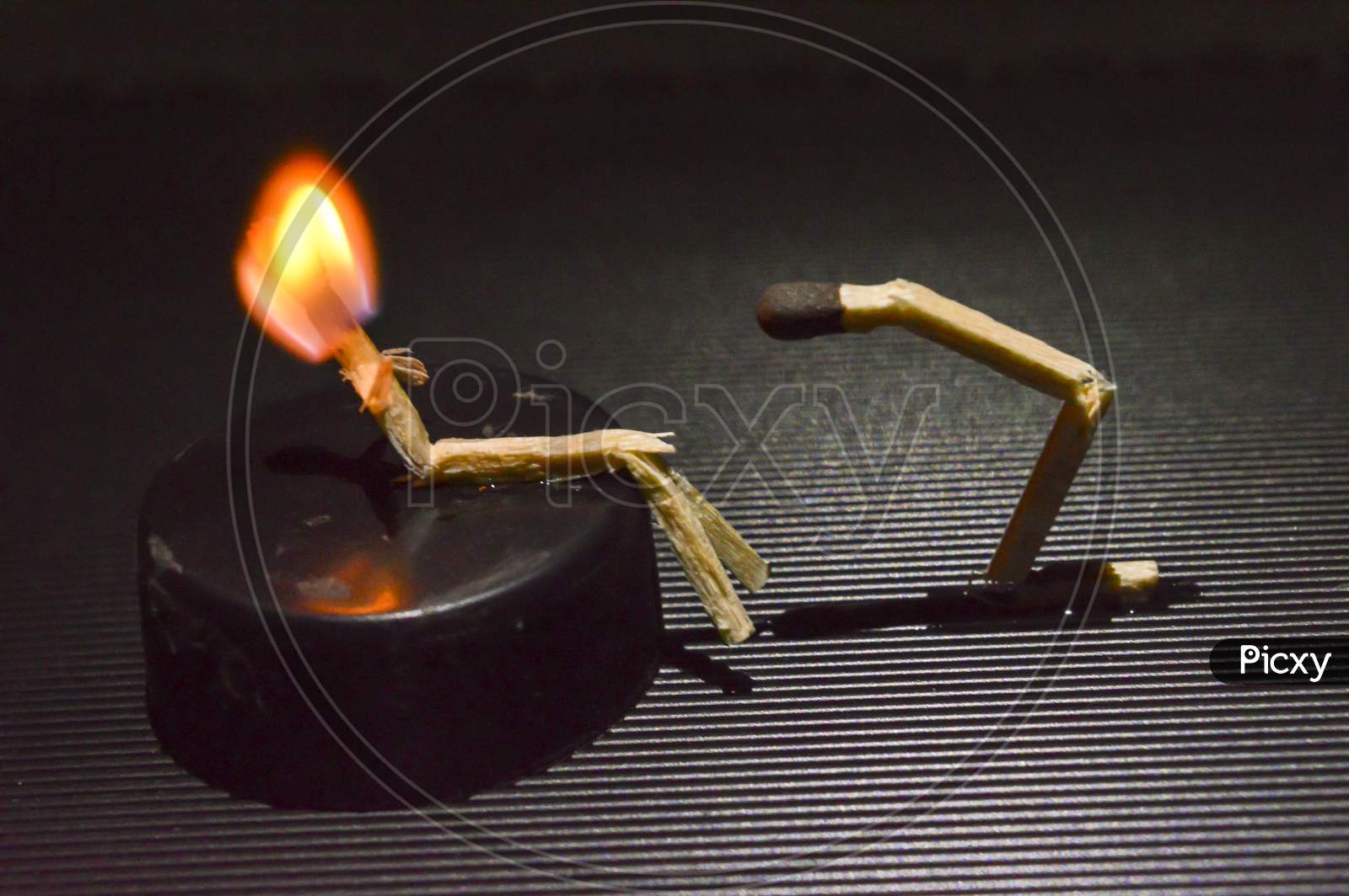 A Miniature Art Of Matchsticks In Form Of A People On Top Of Table.