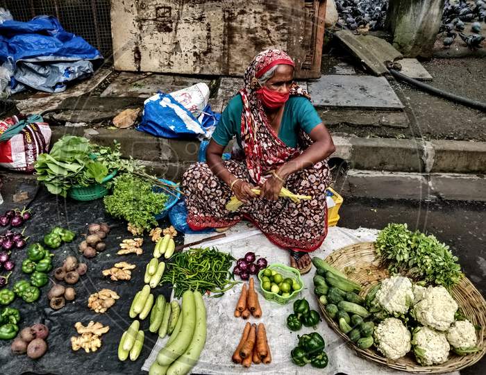 Female vendor selling vegetables on street during COVID-19 outbreak