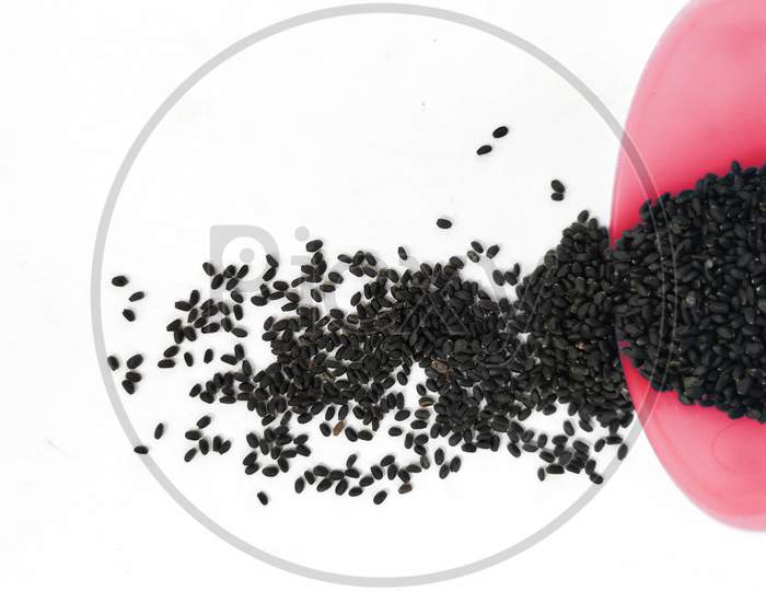 Chia Seeds or Kama Kasturi Seed Scattered from Red Color Plastic Container isolated on White Background.