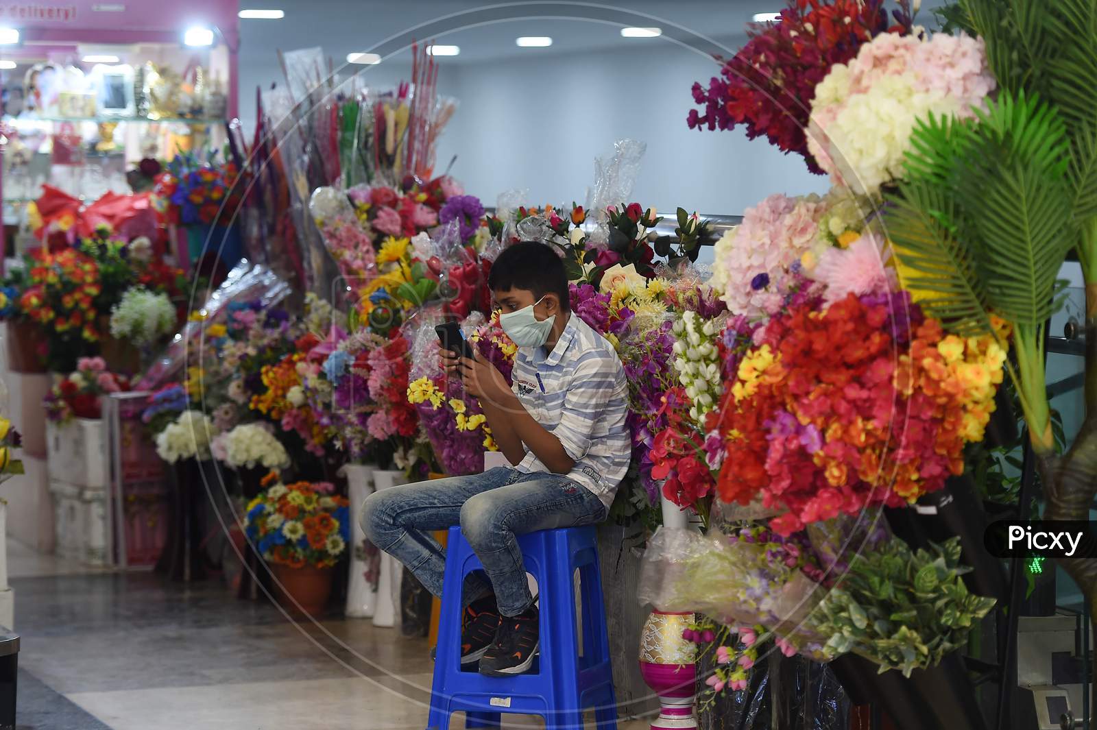 A Young Vendor Checks His A Mobile As He Waits For Customers Inside A Shopping Mall Reopened After The Government Eased A Nationwide Lockdown Imposed As A Preventive Measure Against The Covid-19 Coronavirus, In Chennai On September 1, 2020.