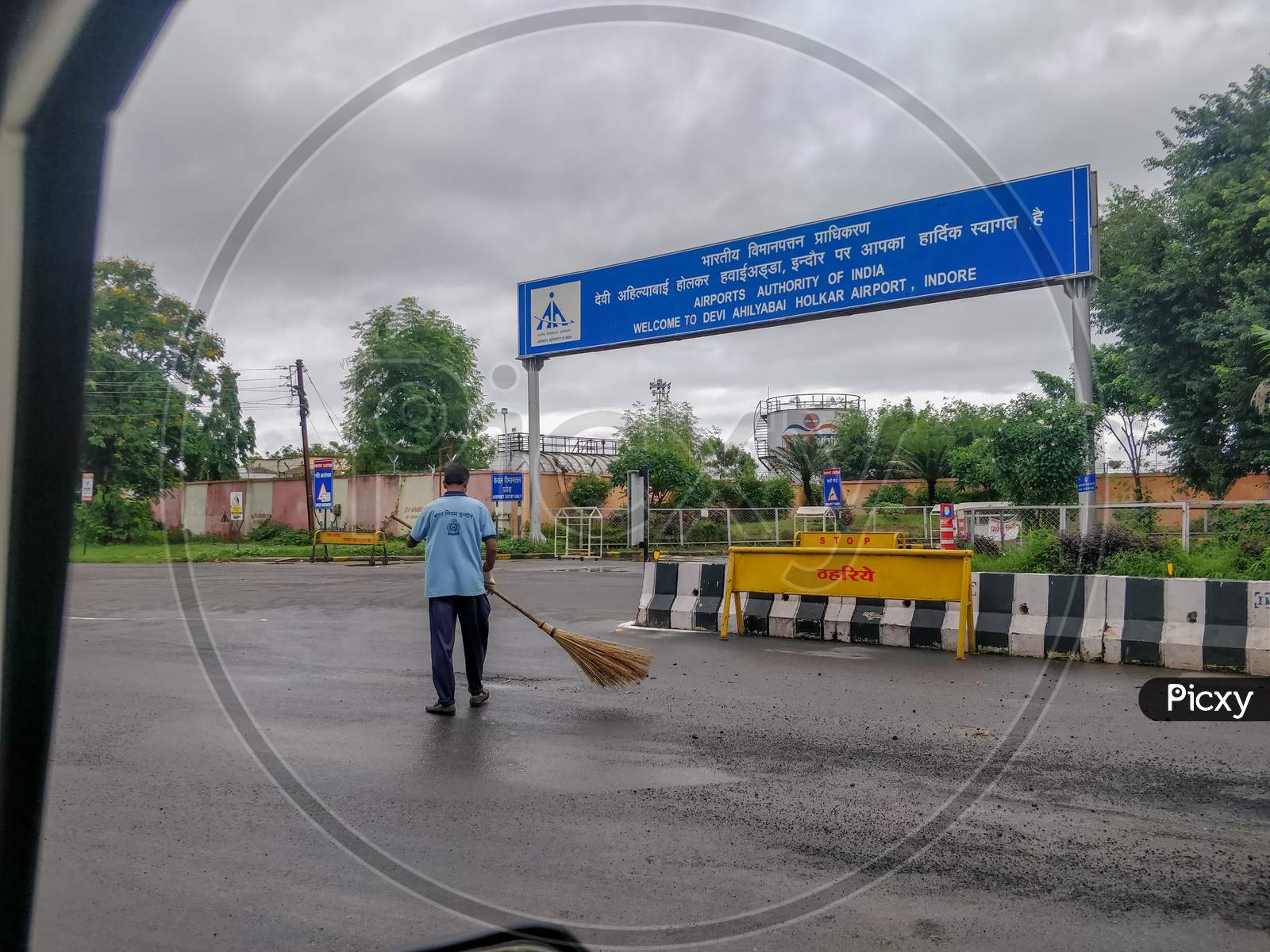 Indore, India - August 22Nd 2020: Worker Cleaning Road Outside Indore Airport.
