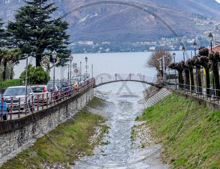 Italy, Varenna, Stream Flowing Into Lake Como With Mountain In Background