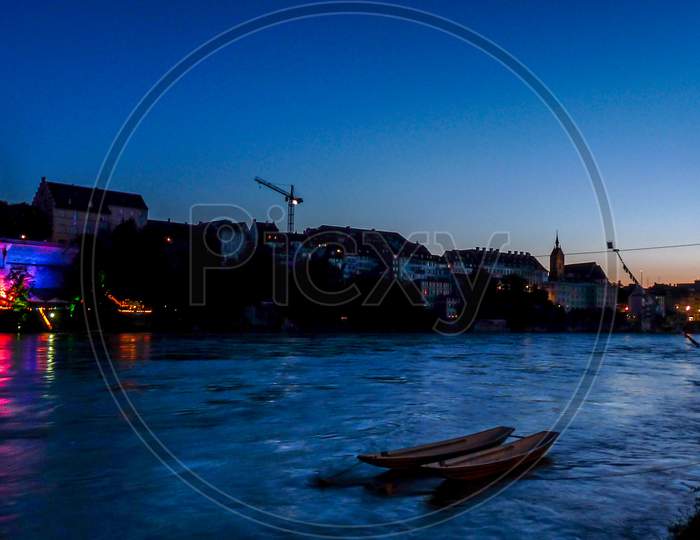 Switzerland, Basel, Silhouette Buildings By Rhine River Against Clear Sky At Dusk