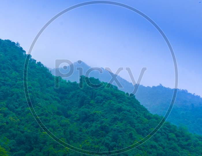 High mountains that cover the sky covered with green grass and trees