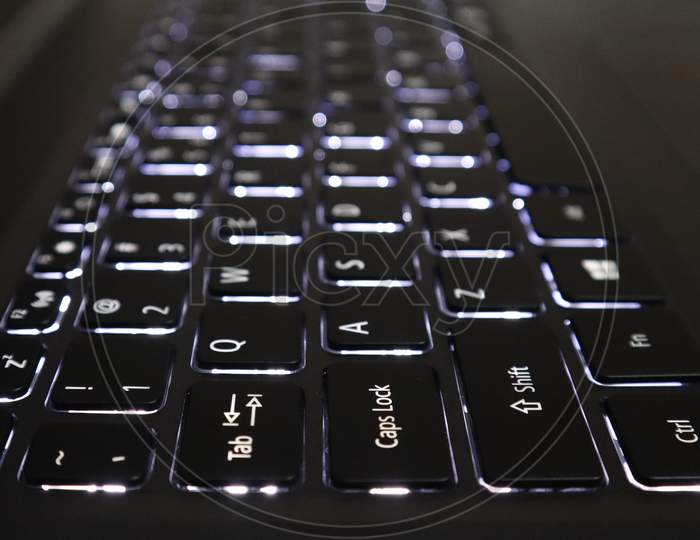 White Backlit Keyboard Of A Laptop With Selective Focus And Blur Background Effect.
