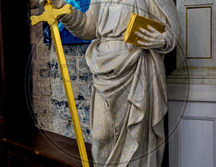 A White Marble Sculpture Of An Scholar With A Sword And A Book In The Interiors Of Saint Nicholas Church, Ghent, Belgium