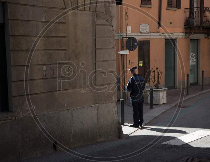 Menaggio, Italy-April 2, 2018: Italian Police Officer Standing In The Corner Of A Narrow Street, Lombardy