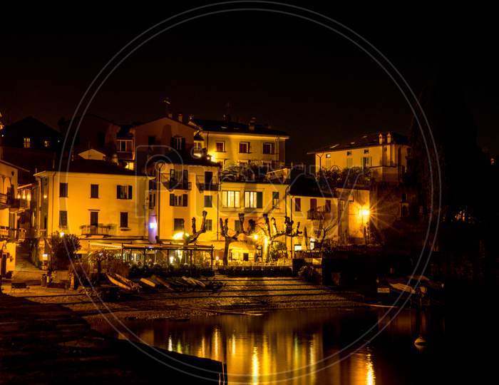 Italy, Varenna, Lake Como, A Lit Up City At Night
