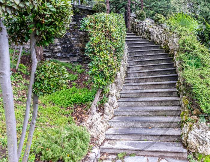 Italy, Varenna, Lake Como, Footpath Amidst Trees And Plants
