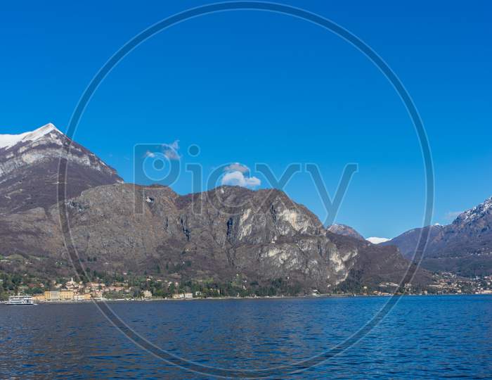 Italy, Bellagio, Lake Como, Cadenabbia, Scenic View Of Sea And Mountains Against Clear Blue Sky