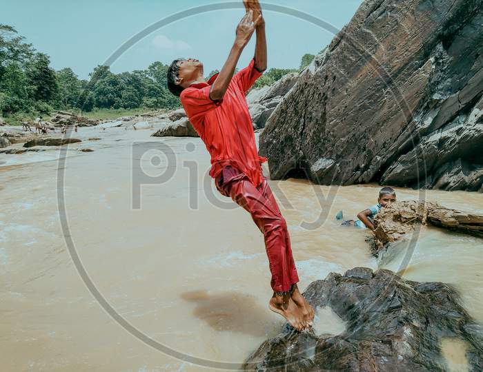 A boy trying to flip in river