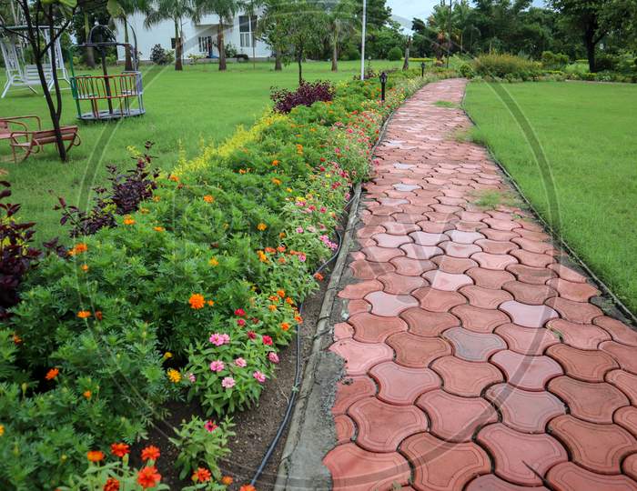 Beautiful Footpath In A Park With Colorful Flowers.