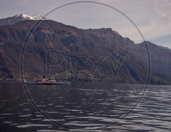 Menaggio, Italy-April 2, 2018: Concordia Ferry Boat On The Lake Como Transporting People With Mountain In Background