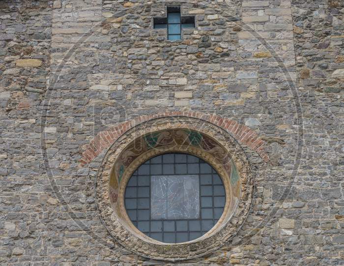 Italy, Varenna, Lake Como, A Stone Building That Has A Clock On The Side Of A Brick Wall
