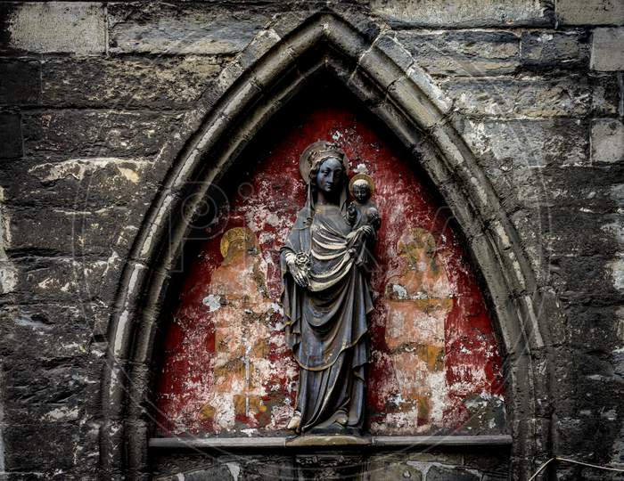 A Sculpture Of Mary And Baby Jesus Under An Arch In Ghent, Belgium