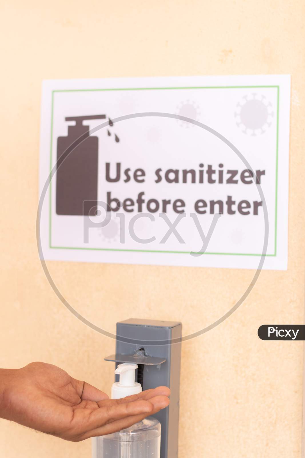 Close Up Of Hands Using Hand Sanitizer Below The Use Sanitizer Before Enter Signage Board On Wall As Safety Measure Due To Coronavirus Or Covid-19 Pandemic