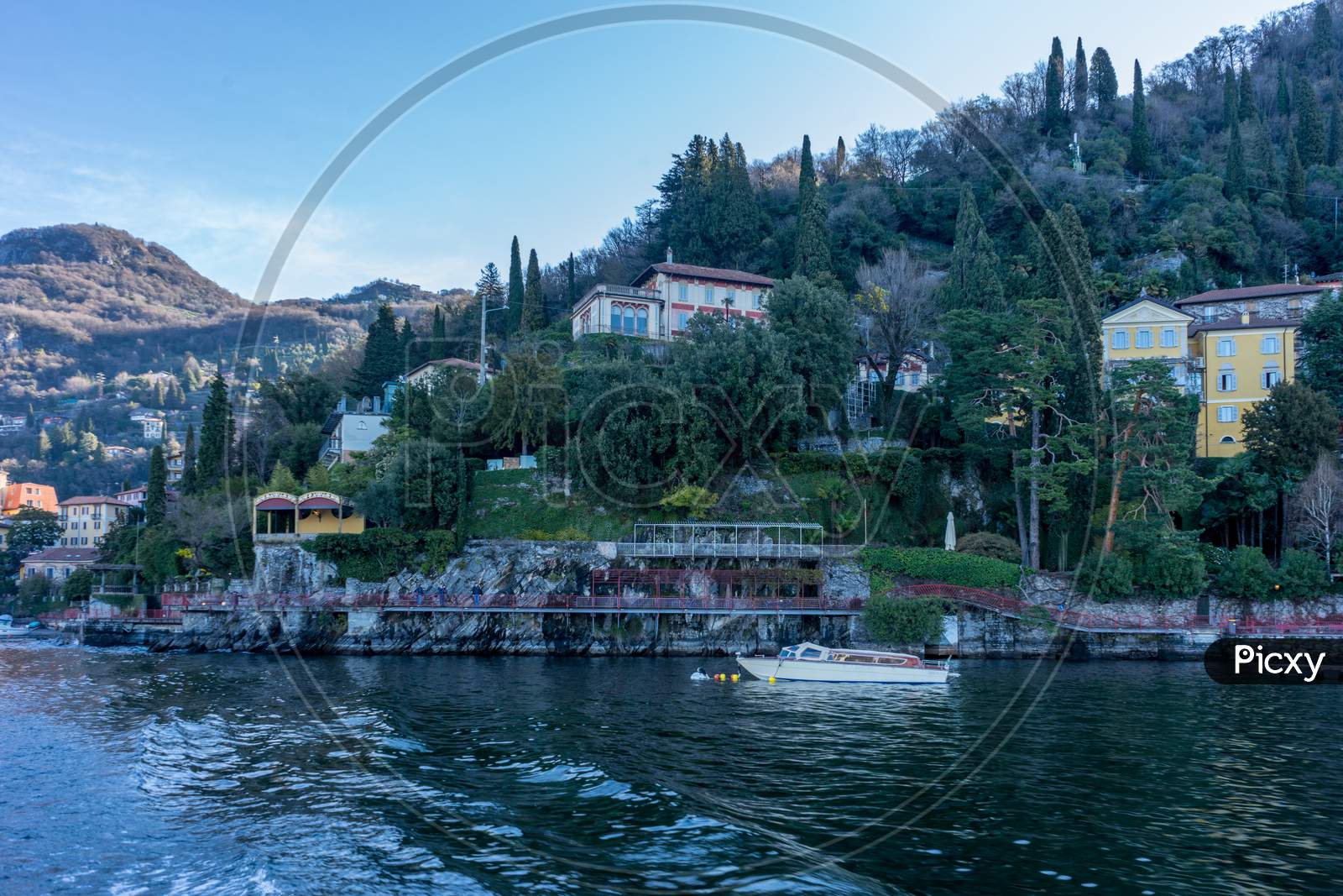 Italy, Bellagio, Lake Como, Lake Como, A Small Boat In A Body Of Water With Lake Como In The Background