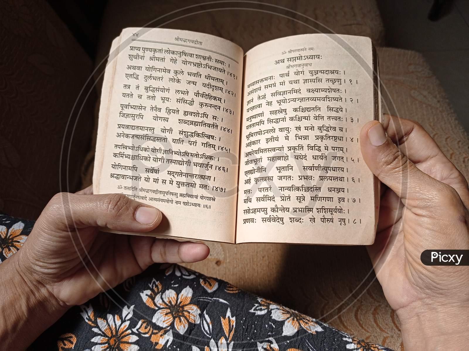 Indian woman reading old Sanskrit religious book bhagvat gita