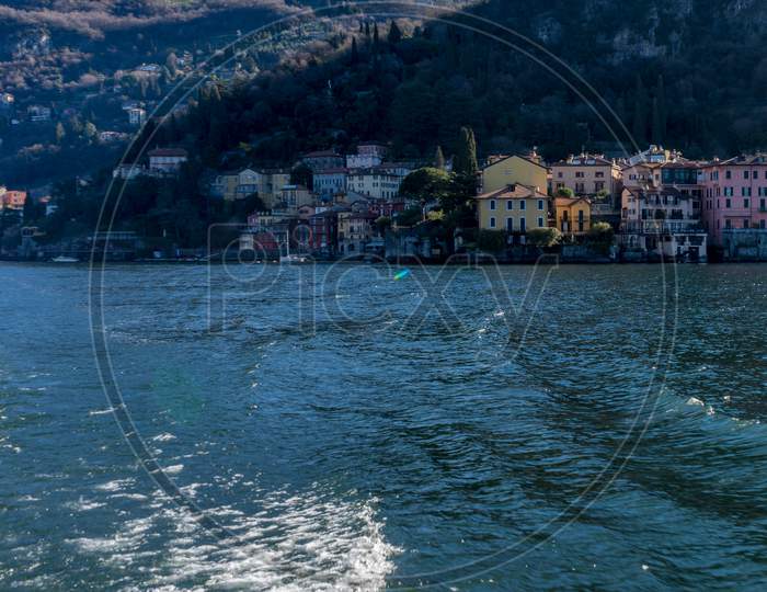 Italy, Bellagio, Lake Como, A Large Body Of Water With A City In The Background