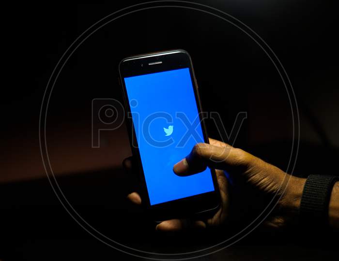 Twitter Mobile App Icon Opening on Smartphone Screen Closeup With Finger