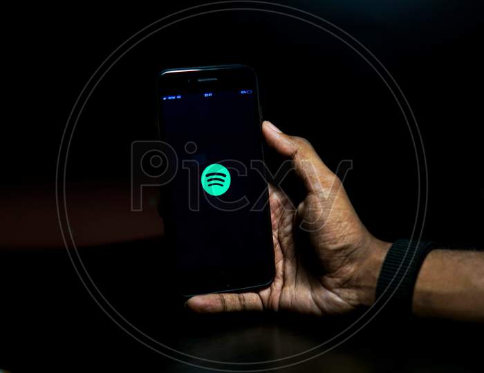 Spotify Mobile App Icon Opening on Smartphone Screen Closeup