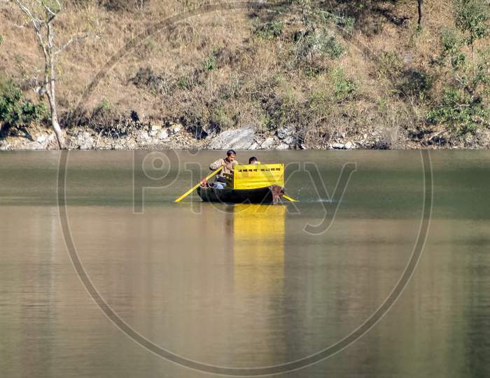 Boatman With Tourist Rowing His Small Yellow Boat In Waters Of Bhimtal Lake.