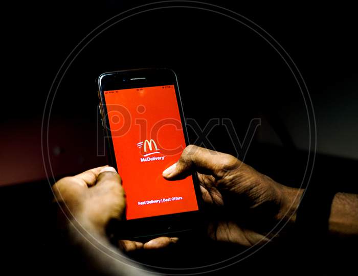 McDonald's Delivery Mobile App Icon Opening on Smartphone Screen Closeup With Finger