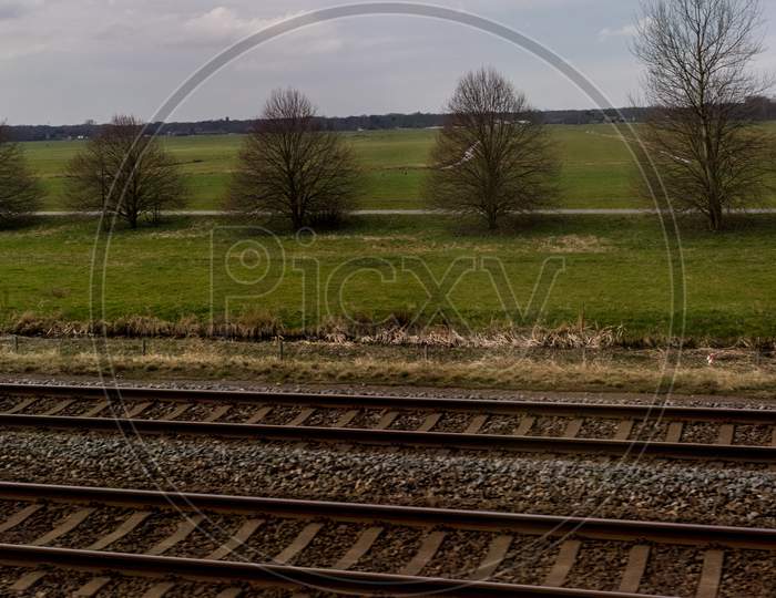 Netherlands, Hague, Schiphol, A Train On A Train Track With Trees In The Background