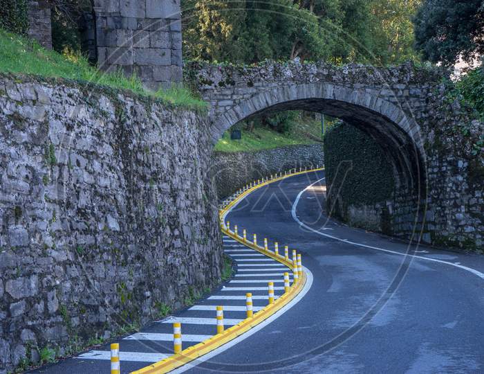 Italy, Bellagio, Lake Como, Winding Road Road Passing Through An Arch Curve