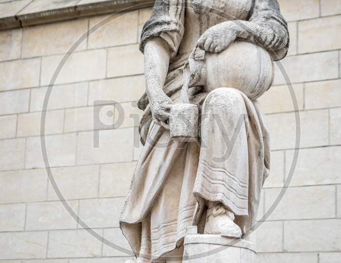 A White Sculpture Of A Woman Pouring Water From A Jug At Brussels, Belgium, Europe