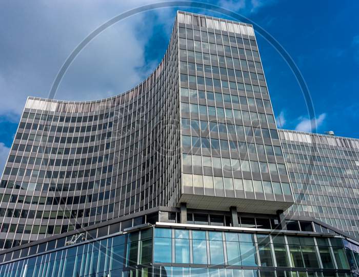 A Tall Glass Building With A Curve Against A Blue Sky At Brussels, Belgium, Europe