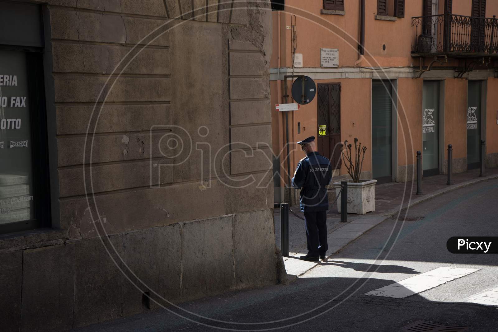 Menaggio, Italy-April 2, 2018: Italian Police Officer Standing In The Corner Of A Narrow Street, Lombardy