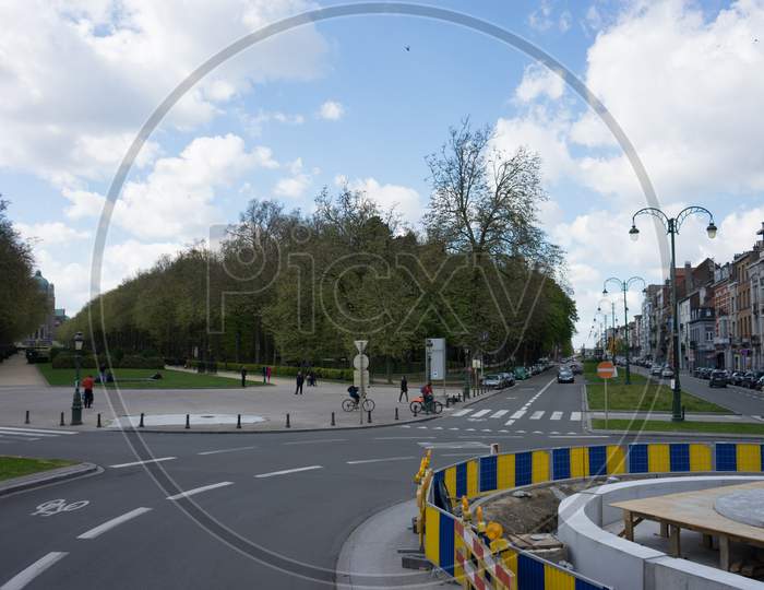 Brussels, Belgium - 17 April 2017: A Cyclist Passes By A Garden On The Streets Of Brussels, Belgium