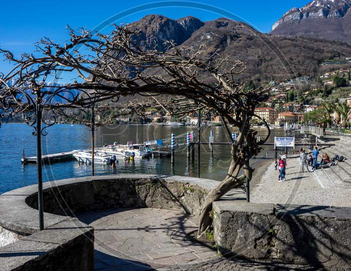 Menaggio, Italy-April 2, 2018: People Relaxing At The Waterside Quay, Menaggio, Lombardy