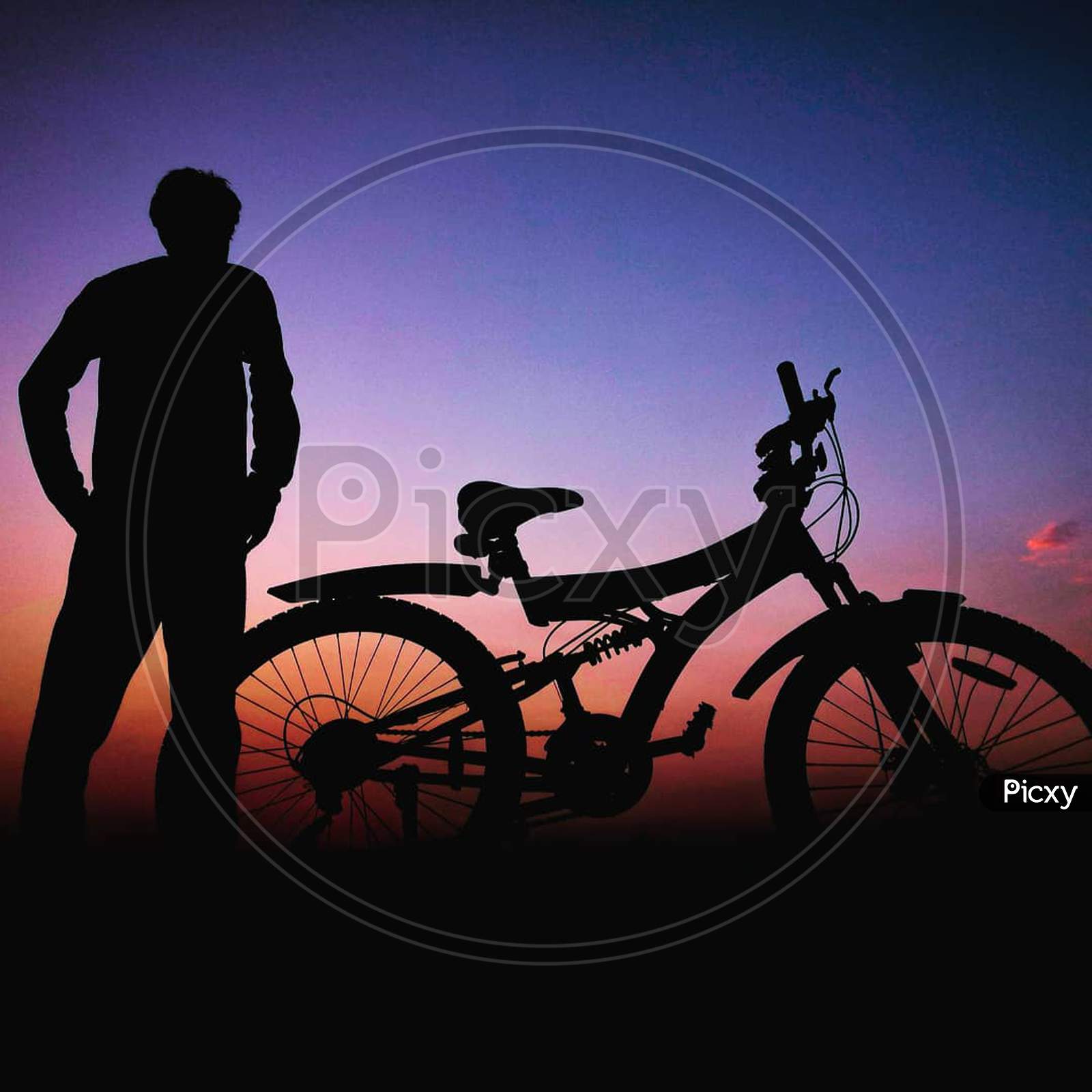 Man with cycle, sunset