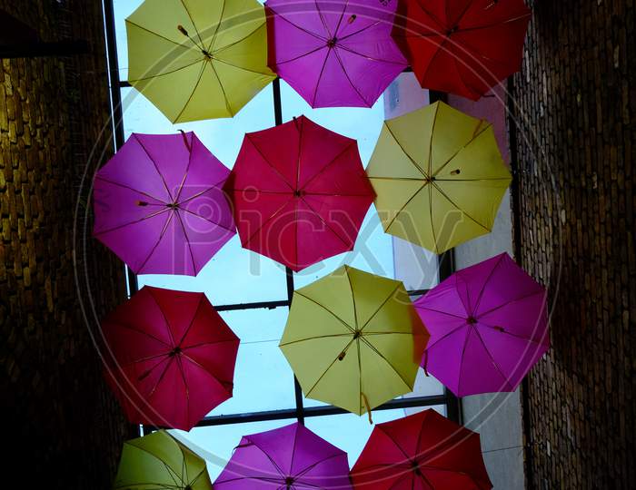 Colourful umbrellas in a moody alleyway