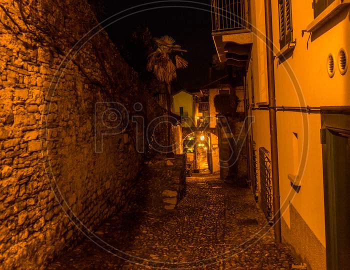 Italy, Varenna, Lake Como, Narrow Alley Amidst Buildings In City At Night