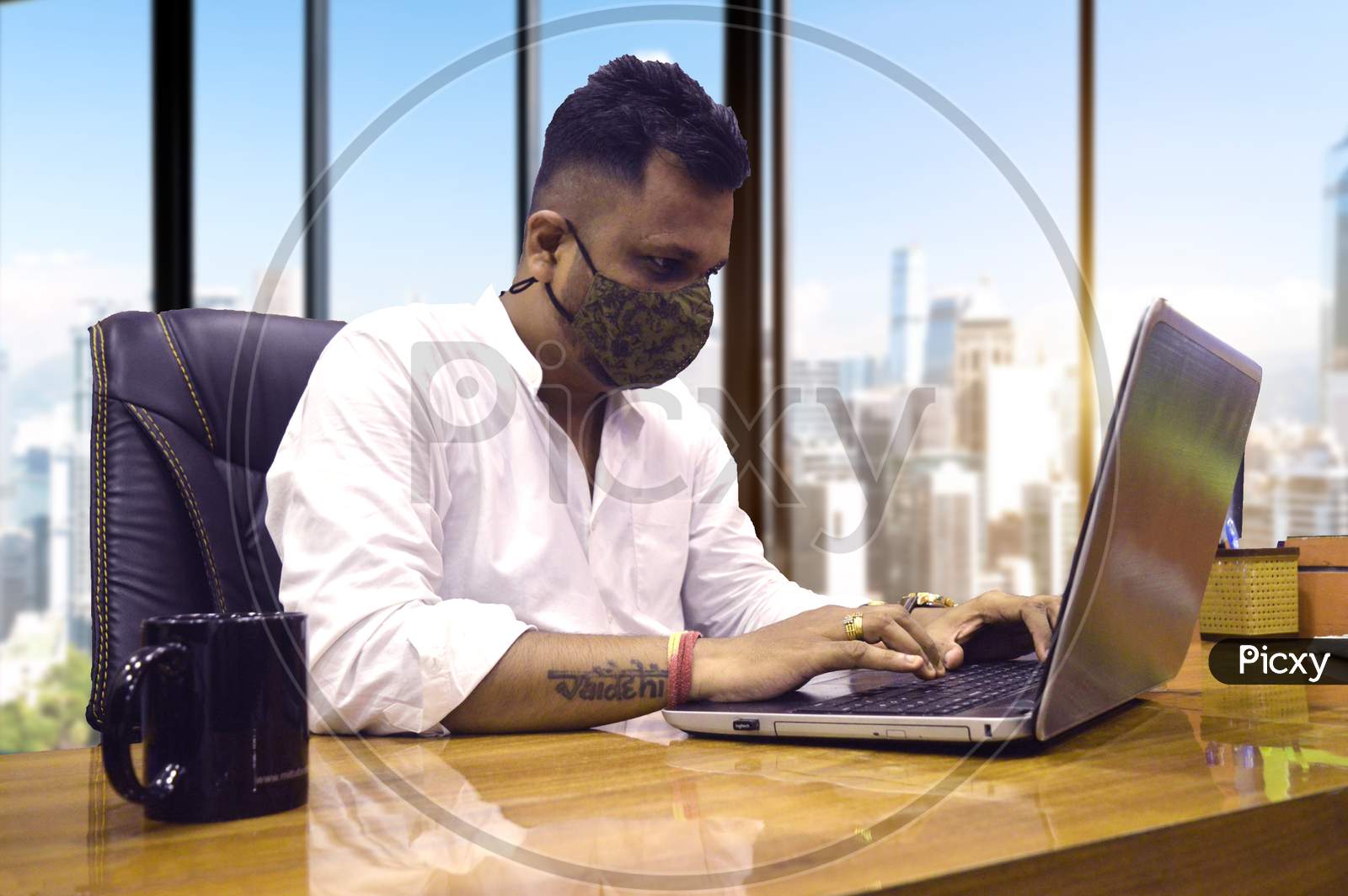 Man working on laptop in office indian with Mask
