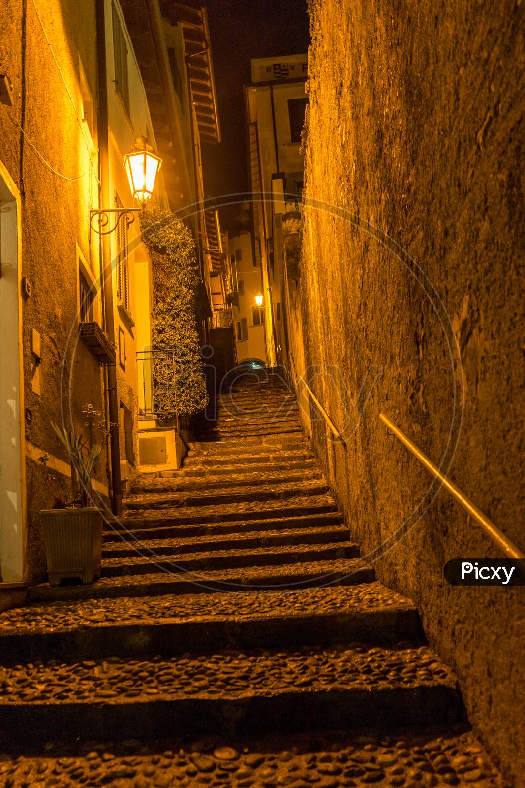 Italy, Varenna, Lake Como, Narrow Street Between Buildings At Night