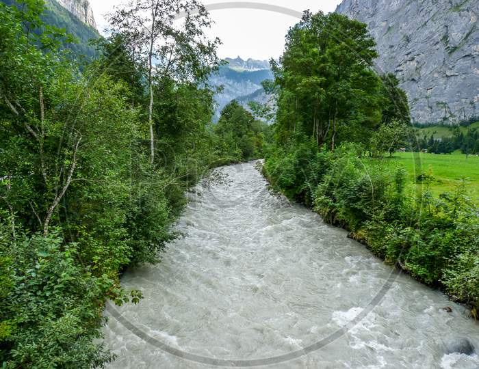 Switzerland, Lauterbrunnen, River Flowing Amidst Trees In Forest