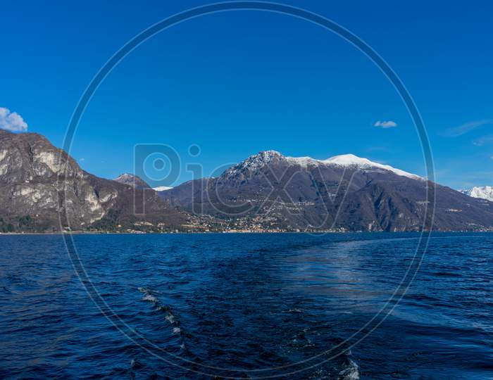 Italy, Bellagio, Lake Como, Cadenabbia, Scenic View Of Sea By Mountains Against Blue Sky