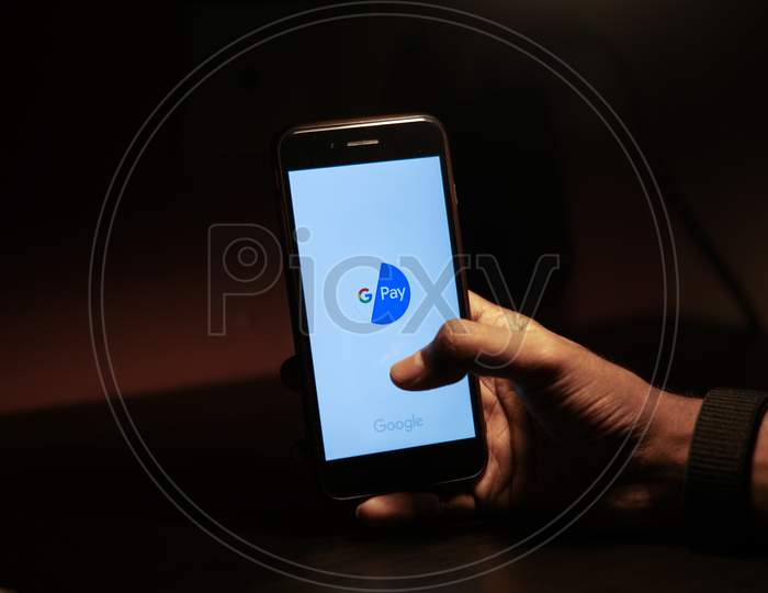 Google Pay Mobile App Icon Opening on Smartphone Screen Closeup With Finger