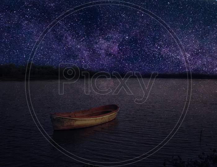 Boat under the milky way in a night sky