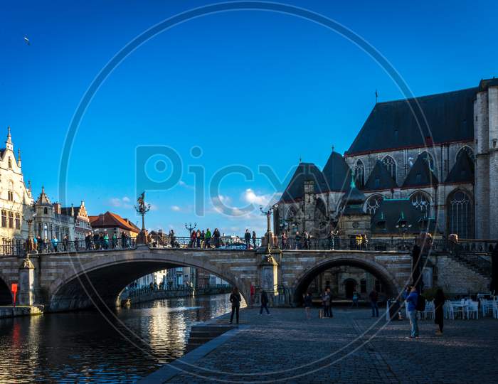 Ghent Belgium - April 15 : Toursists Relax Along The Leie River Bank In Ghent, Belgium