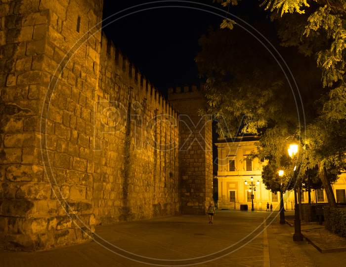 Seville, Spain- June 18, 2017:Tourists Walk On The Street At Night Next To The Alcazar Palace In Seville, Spain June 2017