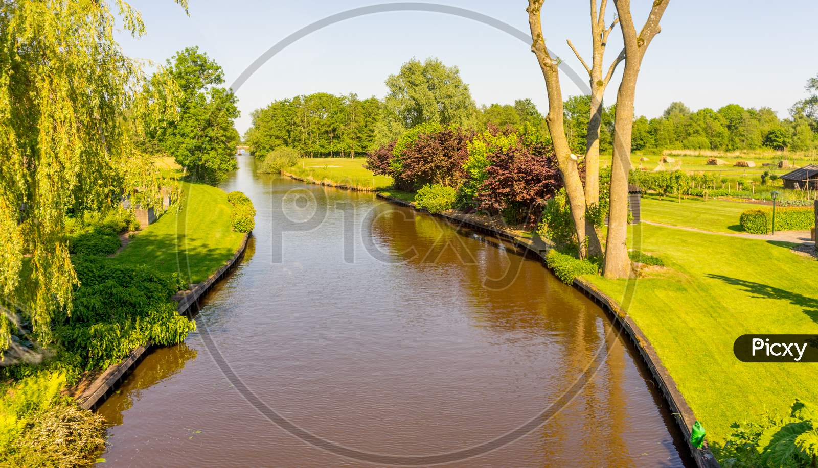 Netherlands, Giethoorn, A Canal Of Water Surrounded By Trees