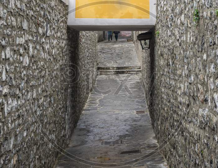 Italy, Varenna, Lake Como, A Passageway Under A Yellow Wall