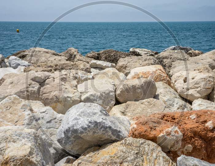 Rocks Against The Green Ocean At Malagueta Beach In Malaga, Spain, Europe